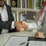 Twee zakenmensen schudden handen na overeenkomst, samenwerking gebaseerd op kwaliteit boven contractvorm