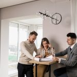 man en vrouw aan tafel met een makelaar